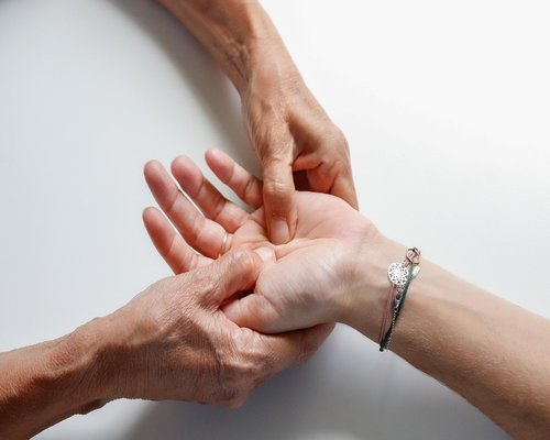 Close-up of a person doing gentle hand and wrist stretches indoors